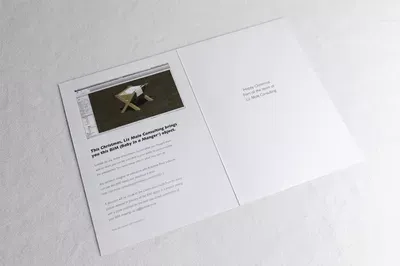 An open brochure or pamphlet displayed on a white surface, with the left page showing a dark photograph and text, and the right page blank except for small centered text near the top.