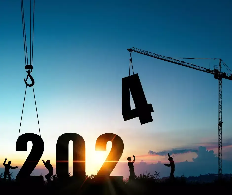 Silhouetted construction workers position large numbers spelling 