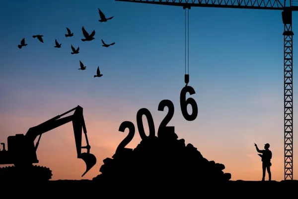 A silhouette of construction equipment and workers building the year 2026, set against a sunset sky with birds flying overhead, symbolizing future development and growth in the construction industry.