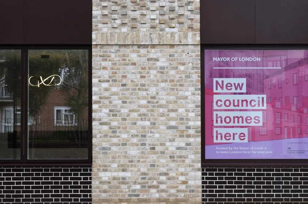Three storefronts with contrasting brick and tile patterns: left shows a dark storefront with gold neon signage, center displays a light cream-colored brick facade, and right features a purple 