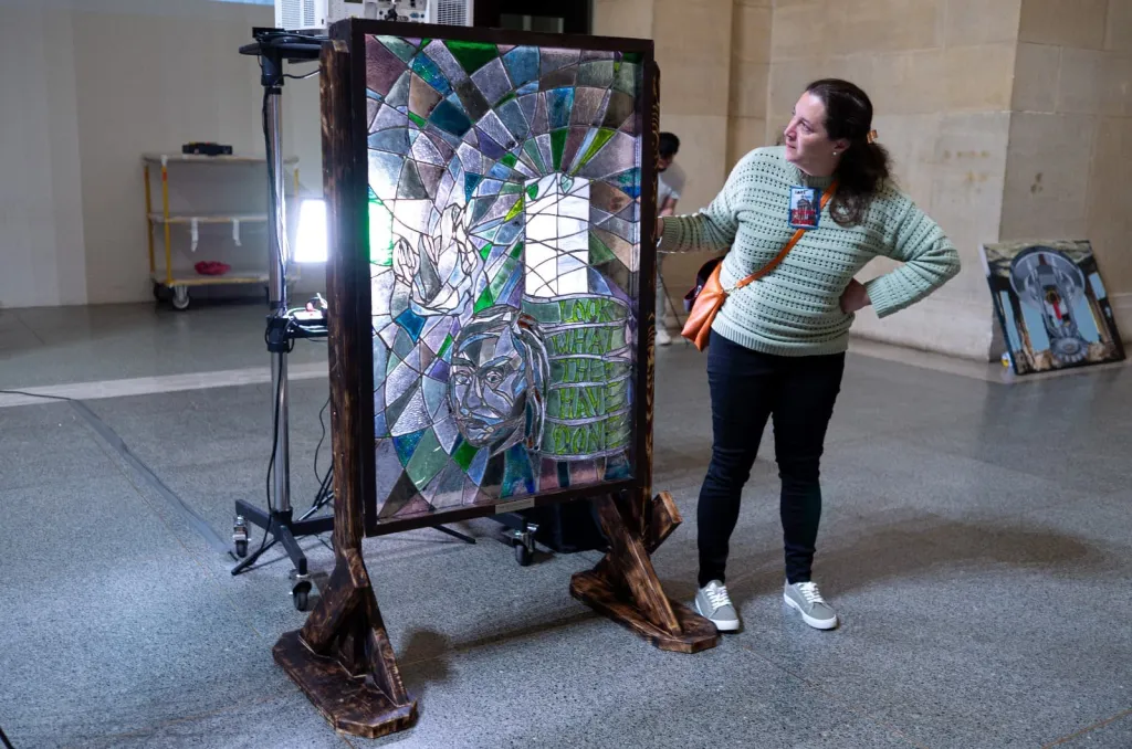 Hannah Mansell with stained glass artwork of Grenfell Tower tragedy