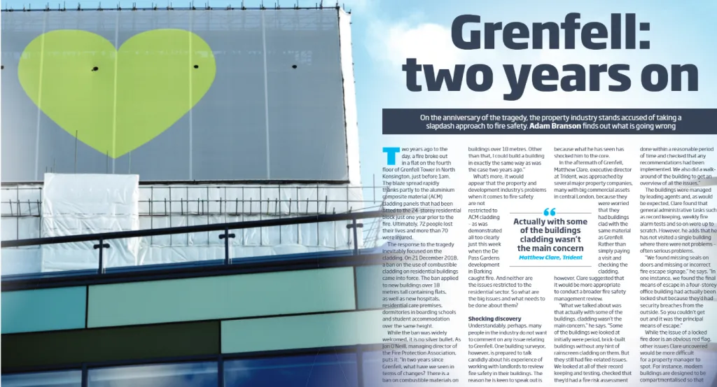 A large green heart-shaped mural adorns the facade of a modern building with horizontal colored bands in turquoise and darker tones. Alongside the mural, a headline reads "Grenfell: two years on" with accompanying article text discussing the Grenfell Tower fire and its aftermath.